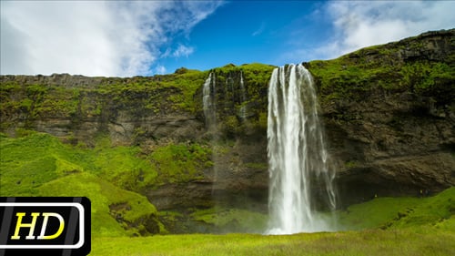 Scenic Waterfall Flowing over Mossy Green Cliffs