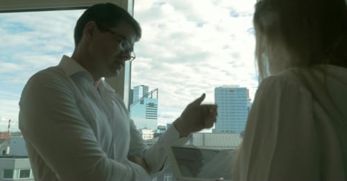 Man and Woman Discuss City View Using Tablet