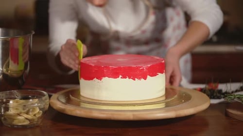 Woman Decorates Delicious Cake with Red Icing