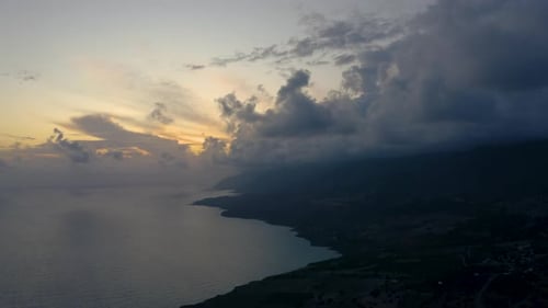 Flying above Ocean Coast line at dusk. Aerial drone view of Sea landscape. Beautiful clouds