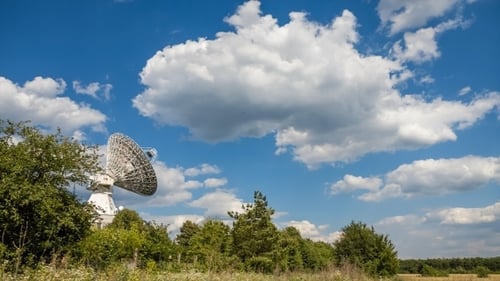 Satellite Dish Against a Blue Sky with Clouds