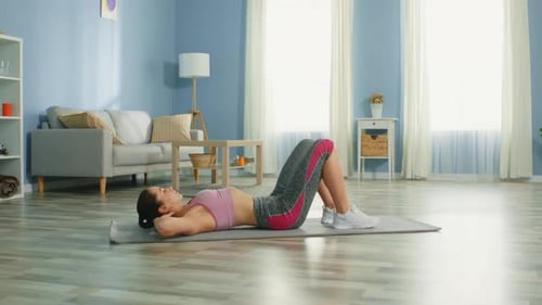 Fit Woman Doing Crunches on Mat at Home