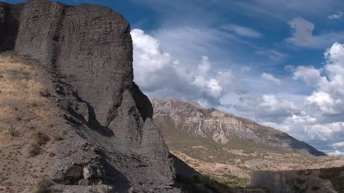 Flying towards rocky cliff face looking toward mountain top