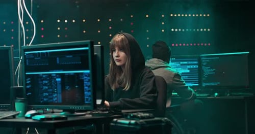 Woman and Man Working at Computers Late at Night