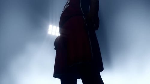 Basketball Player Standing in Stadium Lights