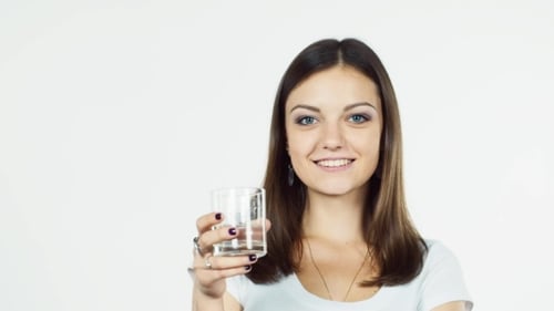 Attraktives brünettes Trinkwasser auf weißem Grund