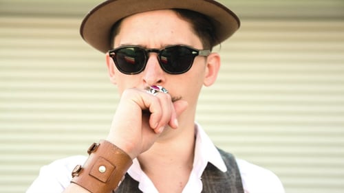 Man with Moustache and Hat Addresses Viewer