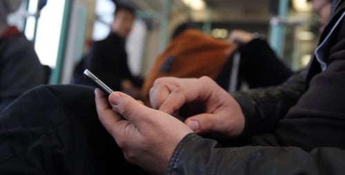 Man Uses Smartphone on a Moving Train