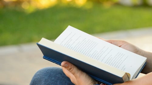 Woman Reading a Book in a Park