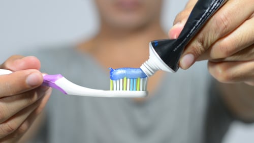 Man Putting Toothpaste on Tooth Brush