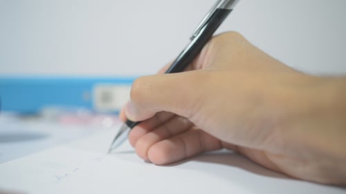 Close Up Writing on Paper at Desk