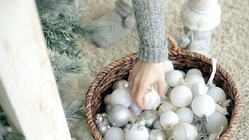 Woman Prepares Christmas Ornaments for Tree Decoration