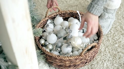Woman Prepares Basket of Ornaments for Christmas Tree