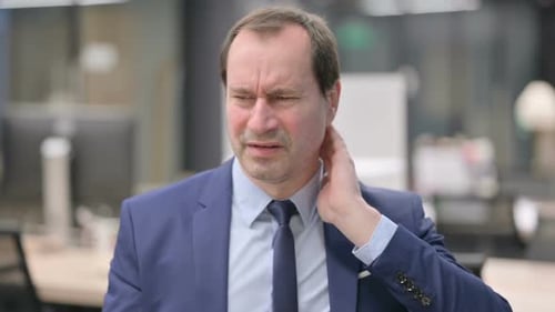 Man Rubbing Neck in Office, Experiencing Pain