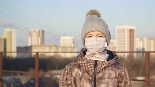 Woman Wearing Face Mask Holding Hand Up