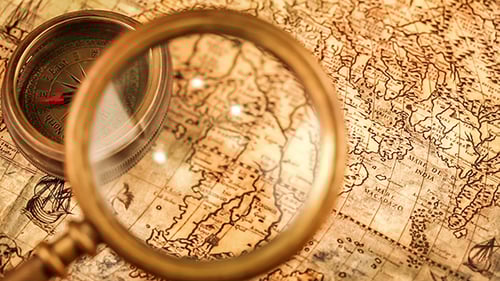 Magnifying Glass on Vintage Map with Compass