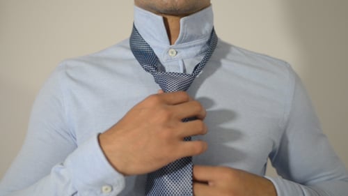 Man Adjusting Tie in the Mirror, Close Up