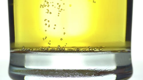 Close Up of Bubbles Rising in Yellow Drink