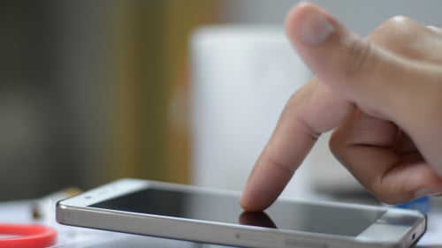 Finger Tapping Smartphone Screen in Close Up