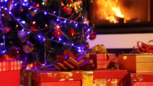 Gifts Sit Under Christmas Tree by Fireplace