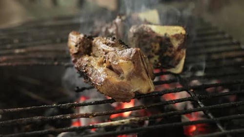 Meat Grilled Over Charcoal Griller With Smoke. - close up