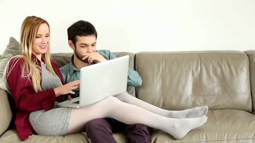 Young Couple Using Laptop on Couch Together