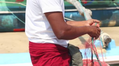 Close Up Of Local Fisherman Sorting Nets On Beach After Long Night Working, Weligama, Sri Lanka