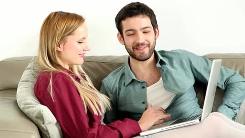 Couple Relaxing Using Laptop on Couch at Home
