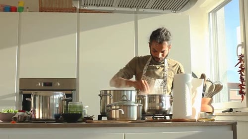 Man Cooking at the Stove in Bright Kitchen