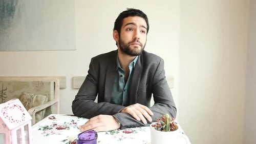 Handsome Young Man Waiting For His Date In A Cafe