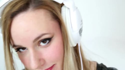 Smiling woman with white headphones listening to music