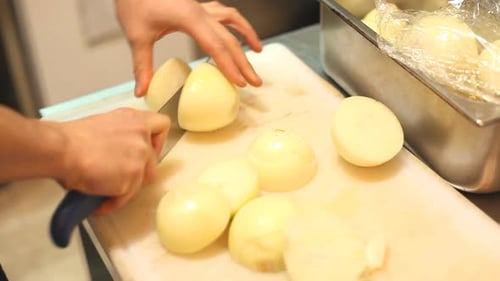 Hands Slicing Fresh Onions with a Knife