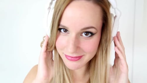 Young Woman with Headphones Adjusting Earphones Close Up