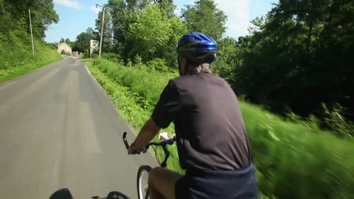Zeitlupe - Mann radelt auf der Straße auf dem Land 1