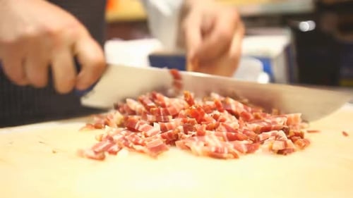 Chef Dicing Cured Meat on Cutting Board