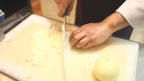 Dicing Fresh Onion with Knife on Cutting Board