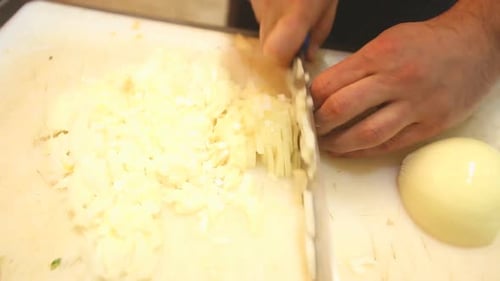 Chef Dices an Onion on Cutting Board
