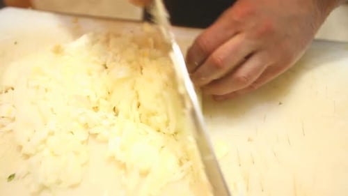 Hands Dicing Fresh White Onion With Knife