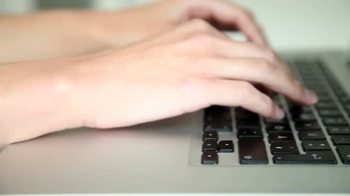 Hands Typing on Laptop Keyboard Close Up