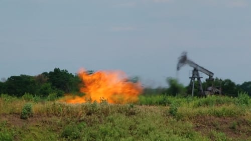 Oil Field Fire with Distant Pump in Rural Area
