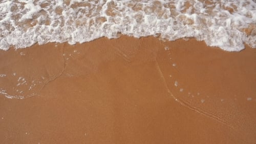 Am Sandstrand eintreffende Meereswellen