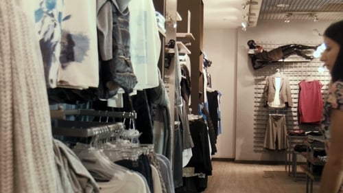 Two Young Girls Choose Clothes In Shop