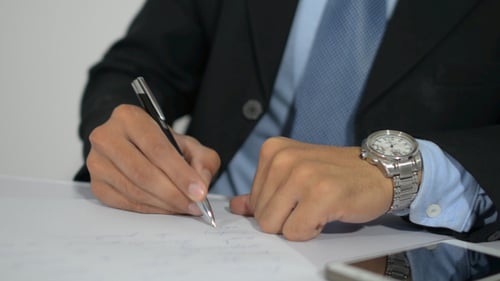 Business Man Writing Notes at a Table