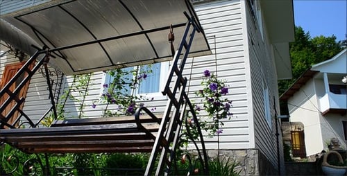 Suburban Home with Swinging Bench Surrounded by Greenery