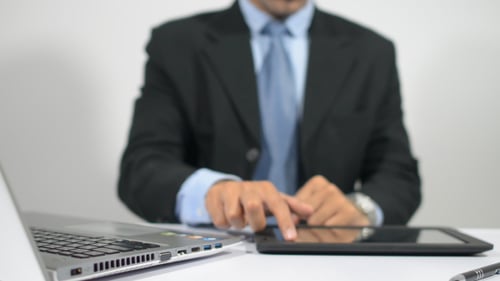 Arbeiten am Tablet und Tippen auf dem Laptop im Büro