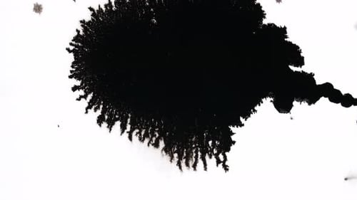 Black Ink Spreading on White Surface