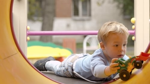 Child Playing with Toy Tractor on Playground