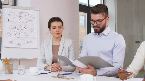 Business Team Reviewing Documents in Bright Workplace