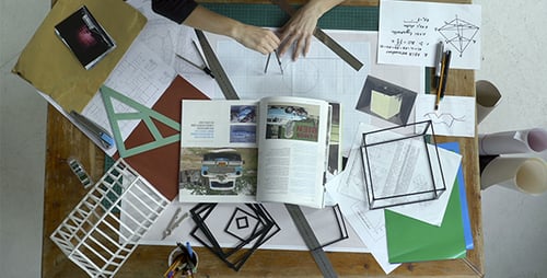 Overhead View of Architect Drafting Plans on Table