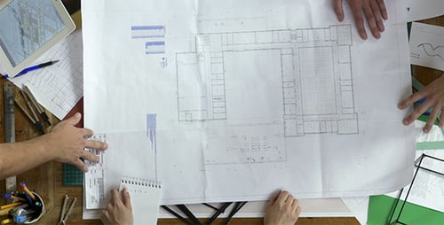 Architects Reviewing Floorplan Drawing at Meeting